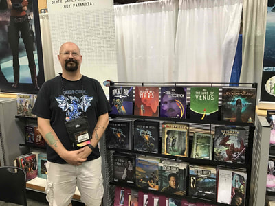 Ken Spencer at the Studio 2 booth with Rocket Age at Gencon 